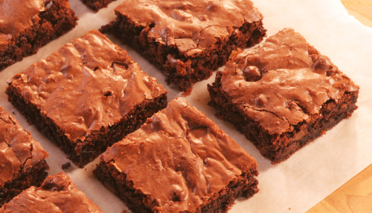 Quadrados de brownie recém-assados, com uma superfície levemente crocante e textura macia por dentro.