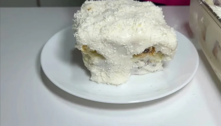 Porção de bolo gelado de Bolo Pullman coberto com coco ralado, pronta para ser saboreada.