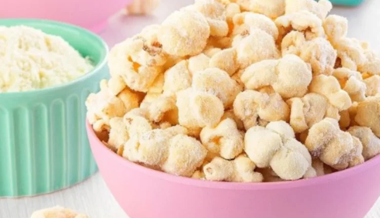 "Pipoca coberta com leite em pó, servida em uma tigela rosa, pronta para saborear."