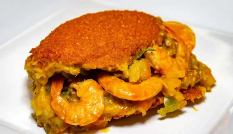 Acarajé recheado com camarão, uma iguaria tradicional da Bahia, servida com uma crosta dourada e recheio suculento.