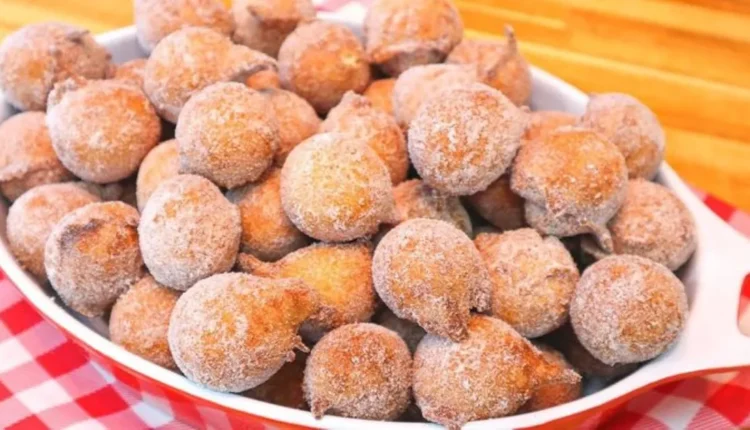 Bolinhos de chuva empanados com açúcar e canela, crocantes e sequinhos em uma tigela branca.