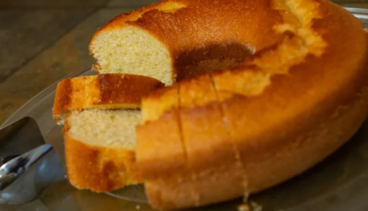 Fatias de bolo de fubá cortado, com uma crosta dourada, servido em prato