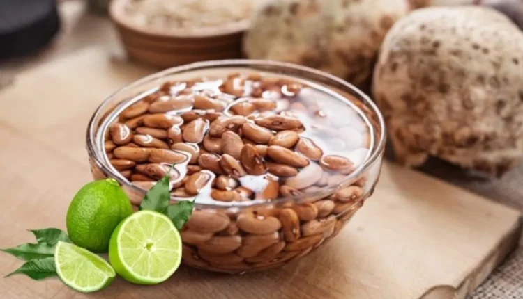 Feijão de molho com rodelas de limão ao lado, pronto para o preparo na cozinha