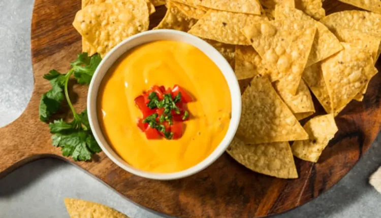 Nachos crocantes servidos com molho cremoso de queijo e toque de pimenta