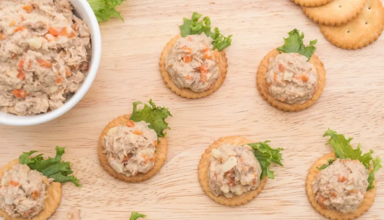 Patê de atum servido sobre bolachas com folhas de alface.