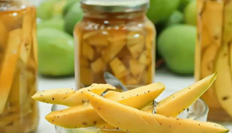 Frascos de picles de manga verde em vidro, com pedaços de manga temperada visíveis.