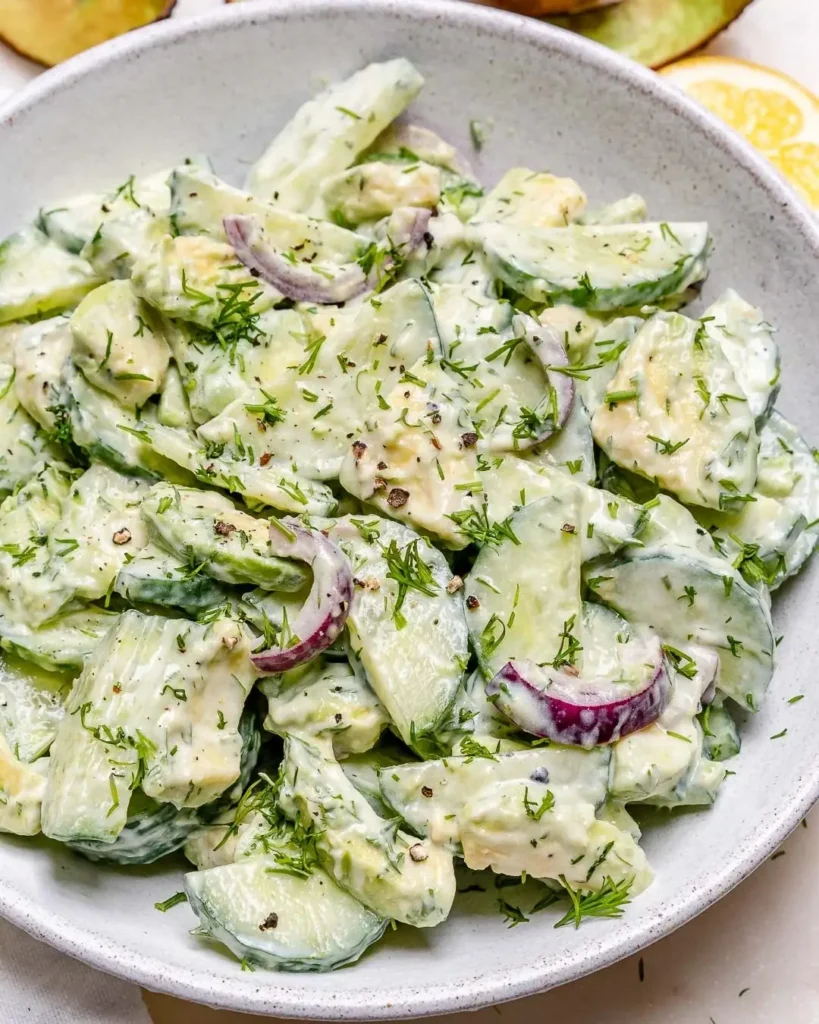 Salada de pepino personalizada Salada de pepino com cebola roxa e ervas frescas, servida em uma tigela
