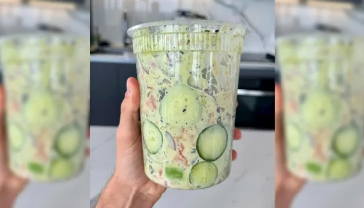 Salada de pepino fresca e colorida, com fatias de pepino e outros ingredientes visíveis em um recipiente grande