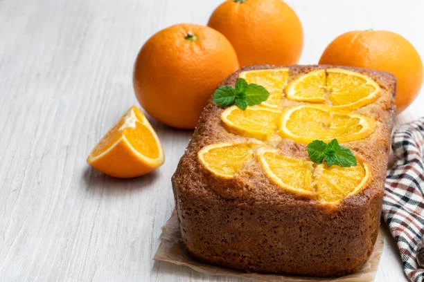 Bolo de laranja tipo Pullman com fatias frescas de laranja Bolo de laranja tipo Pullman decorado com fatias frescas de laranja e folhas de hortelã
