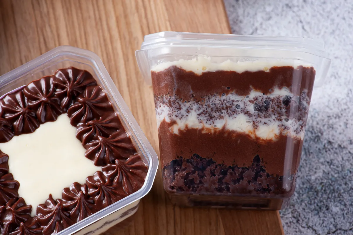 Bolo de pote com chocolate e creme: opção deliciosa para venda Bolo de pote de chocolate com camadas de creme branco.