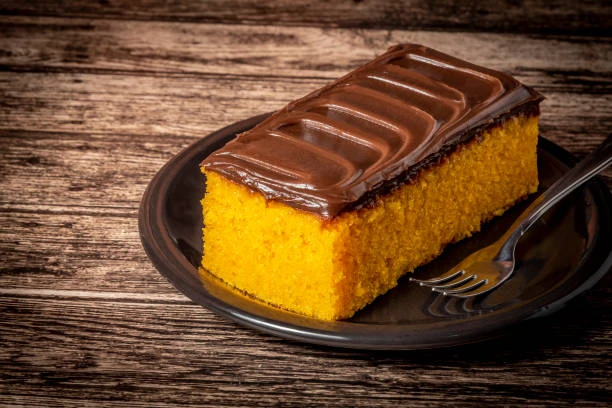 Fatia de bolo de cenoura com cobertura de chocolate Bolo de cenoura macio e úmido coberto com uma camada generosa de chocolate cremoso
