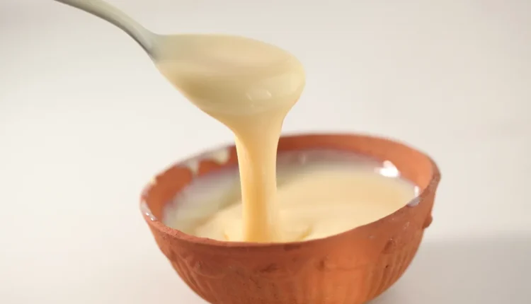 Leite condensado de coco sendo servido em tigela de barro.