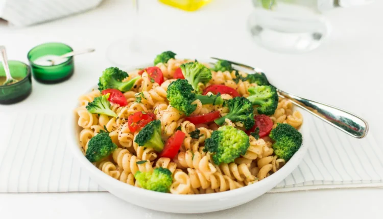 Macarrão Integral com Brócolis - Receita Saudável e Econômica Prato de macarrão integral com brócolis e tomates frescos, uma refeição saudável e saborosa