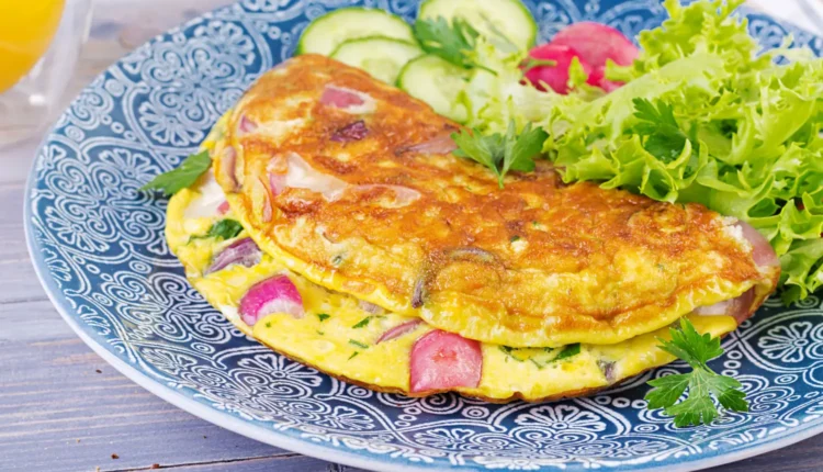 Omelete de Legumes – Prática e saborosa opção para o dia a dia Omelete de legumes frescos com cebola, pepino, e alface, servida em prato colorido