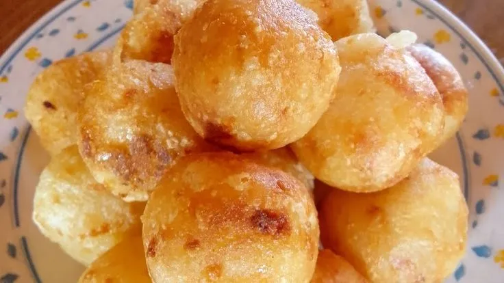 Pão de Polvilho e Mandioquinha - Delícia crocante brasileira Pão de Polvilho e Mandioquinha - Bolinhos crocantes e dourados servidos em um prato decorado.