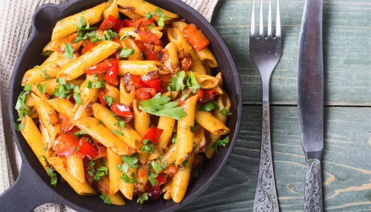 Penne ao molho com pimentão e ervas frescas em frigideira preta