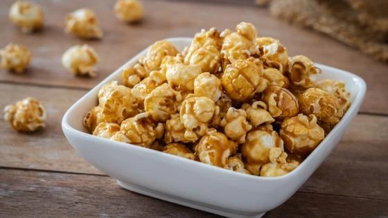 Pipoca de leite em pó na tigela branca Pipoca caramelizada com leite em pó servida em uma tigela branca, ideal para um lanche prático e saboroso