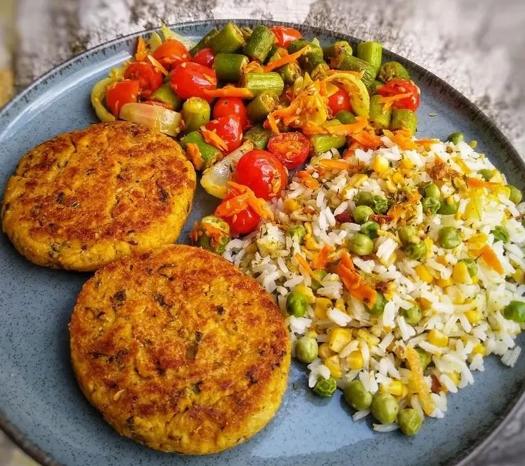Pratinho Vegano Três em Um - Refeição nutritiva e equilibrada Pratinho Vegano Três em Um - Hambúrgueres vegetais, arroz colorido e legumes refogados.