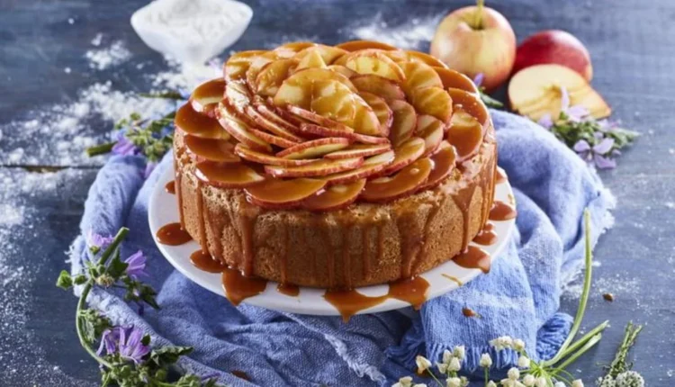 Bolo de maçã com calda de caramelo escorrendo pelas laterais, servido em prato branco