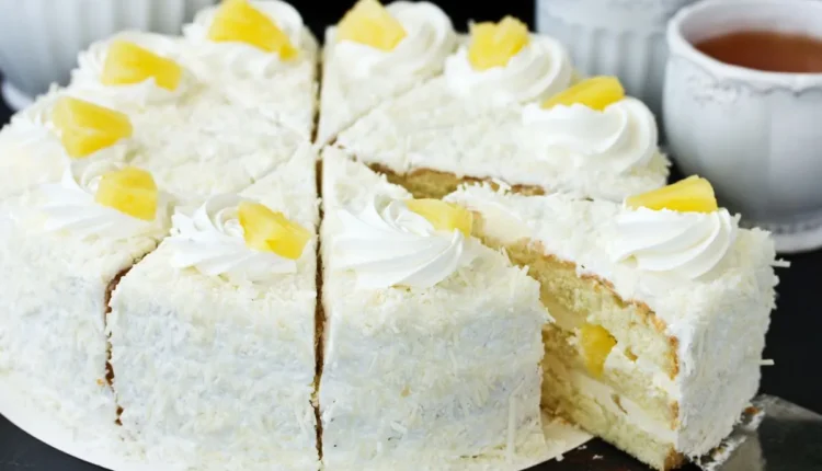 Bolo tropical de abacaxi e coco com cobertura de chantilly, decorado com fatias de abacaxi e creme batido