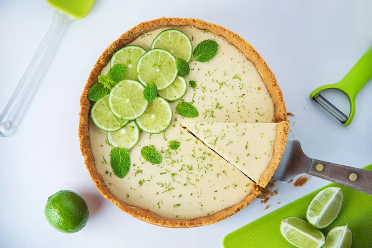 Torta de limão com massa amanteigada, decorada com fatias de limão e folhas de hortelã